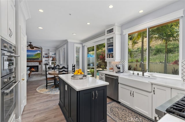 611 Del Dios, San Clemente, CA 92672 - kitchen with appliances with stainless steel finishes, a glass covered fireplace, white cabinetry, healthy amount of natural light, and recessed lighting