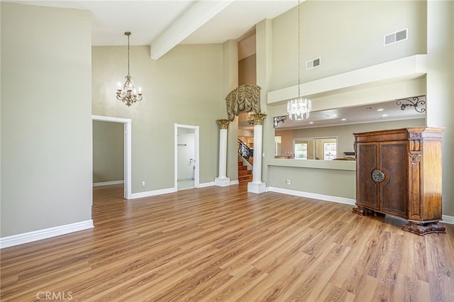 5808 Monterey Pl, Palmdale, CA 93552 - unfurnished living room featuring a chandelier, a high ceiling, stairs, beam ceiling, and light wood-type flooring