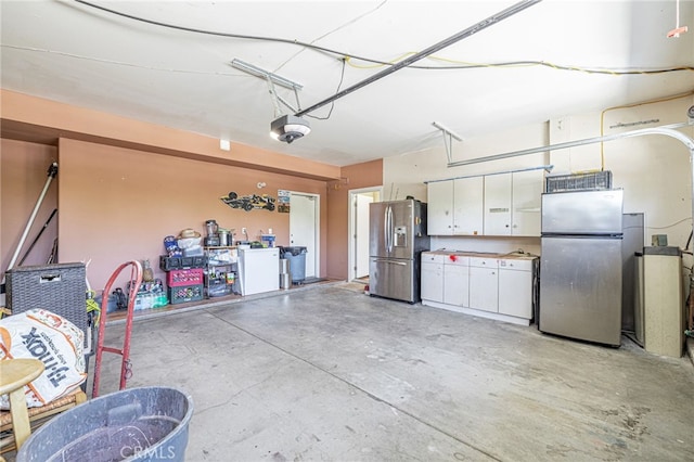 5808 Monterey Pl, Palmdale, CA 93552 - garage featuring freestanding refrigerator, stainless steel fridge with ice dispenser, and a garage door opener