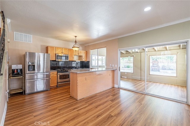 5808 Monterey Pl, Palmdale, CA 93552 - kitchen with stainless steel appliances, a peninsula, light wood-style floors, tasteful backsplash, and ornamental molding