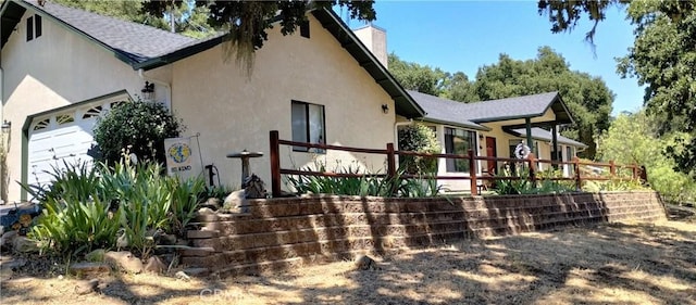 13205 Santa Lucia Rd, Atascadero, CA 93422 - back of house featuring stucco siding, a chimney, and an attached garage