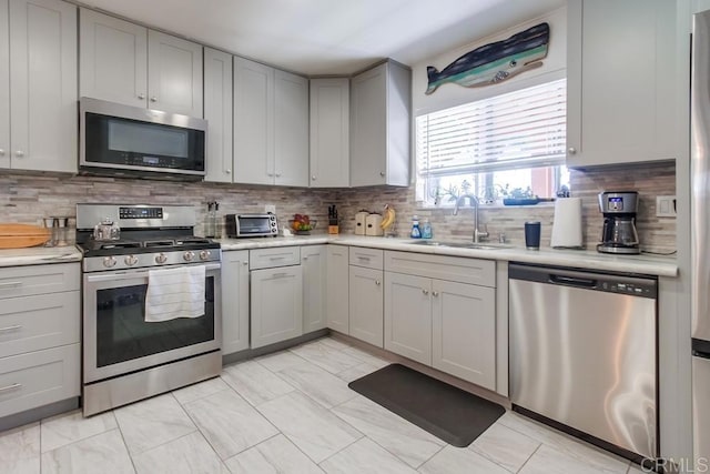 3018 Thunder Dr, Oceanside, CA 92056 - kitchen with stainless steel appliances, gray cabinetry, light countertops, and backsplash