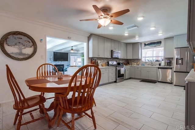 3018 Thunder Dr, Oceanside, CA 92056 - kitchen with appliances with stainless steel finishes, gray cabinetry, a ceiling fan, backsplash, and plenty of natural light