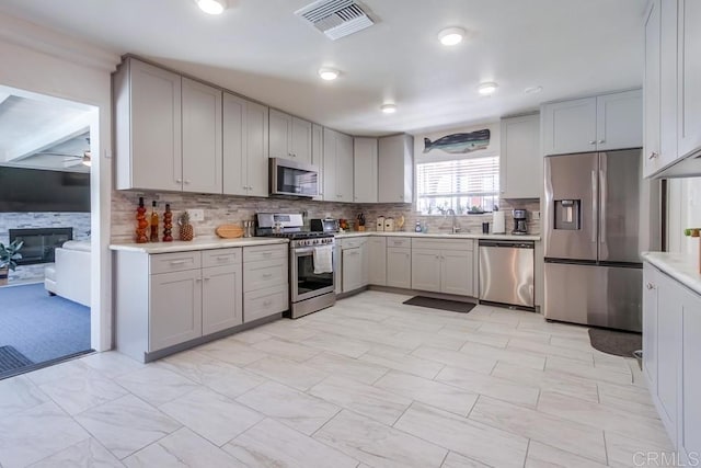 3018 Thunder Dr, Oceanside, CA 92056 - kitchen with appliances with stainless steel finishes, gray cabinets, and tasteful backsplash