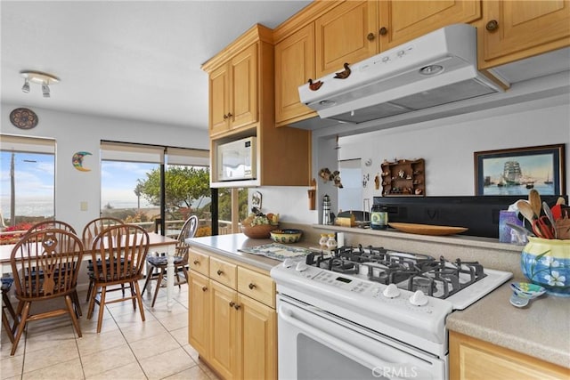 3277 Ocean Blvd, Cayucos, CA 93430 - kitchen featuring under cabinet range hood, white appliances, light countertops, and light tile patterned floors