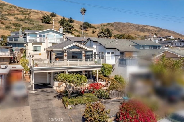3277 Ocean Blvd, Cayucos, CA 93430 - view of front of home featuring a balcony, a mountain view, a porch, a residential view, and an attached garage