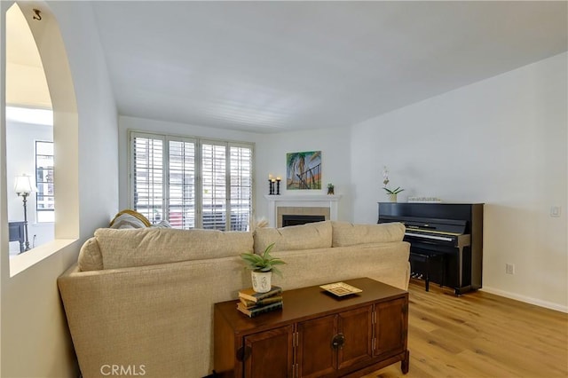 5534 Encino Ave Unit 211, Encino, CA 91316 - living area featuring light wood finished floors, plenty of natural light, a tiled fireplace, and arched walkways