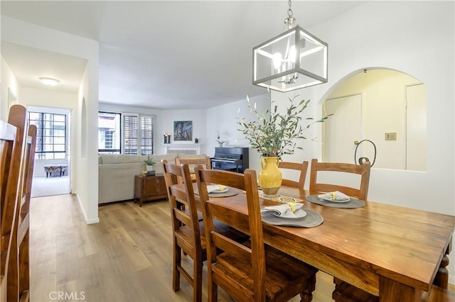 5534 Encino Ave Unit 211, Encino, CA 91316 - dining area featuring light wood finished floors, arched walkways, and a chandelier