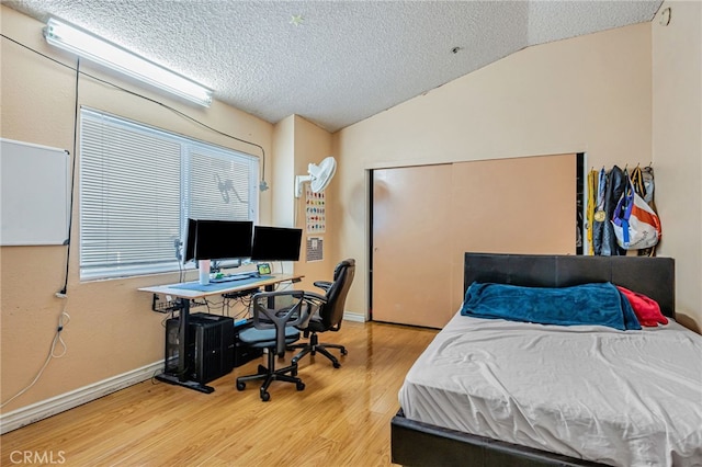 8828 Burnet Ave Unit 9, North Hills, CA 91343 - bedroom with wood finished floors, a textured ceiling, lofted ceiling, a closet, and a desk