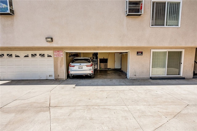 8828 Burnet Ave Unit 9, North Hills, CA 91343 - view of exterior entry featuring an attached garage, stucco siding, and driveway
