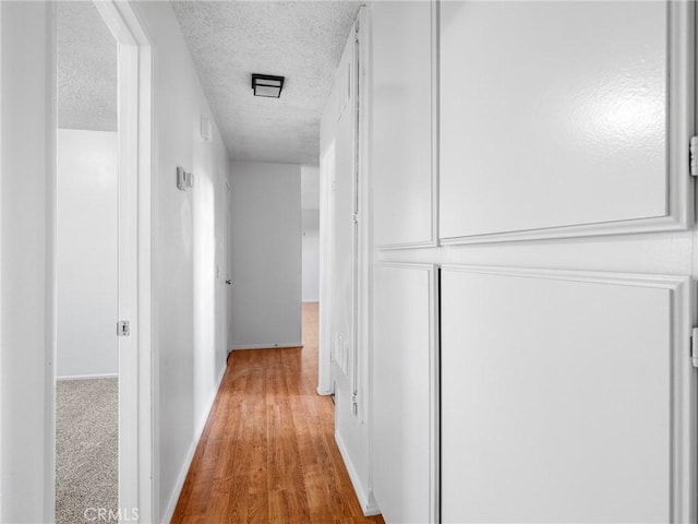 9383 11th Ave, Hesperia, CA 92345 - hallway featuring a textured ceiling and wood finished floors