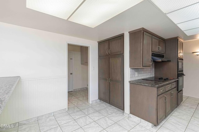 4713 Perris Way, Bakersfield, CA 93309 - kitchen with under cabinet range hood, backsplash, a wainscoted wall, black electric cooktop, and built in microwave