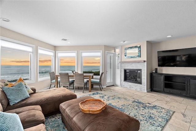 9229 Balboa Ave Unit 4, San Simeon, CA 93452 - living area with a stone fireplace, plenty of natural light, stone tile floors, and recessed lighting