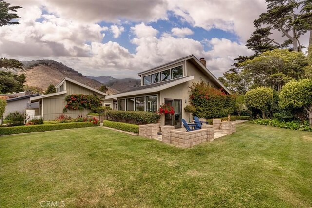 125 Park Pl, Pismo Beach, CA 93449 - view of front of home with a patio, a chimney, a front lawn, a mountain view, and stucco siding