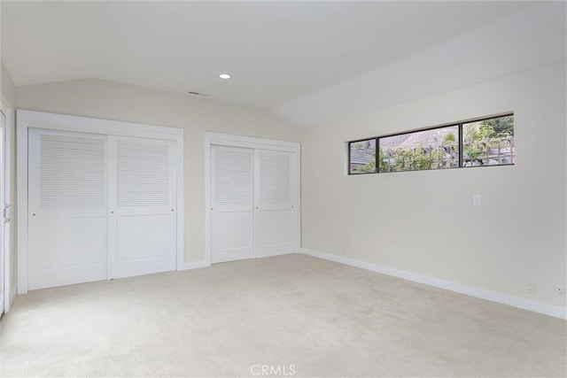 125 Park Pl, Pismo Beach, CA 93449 - unfurnished bedroom with vaulted ceiling, two closets, light carpet, and recessed lighting