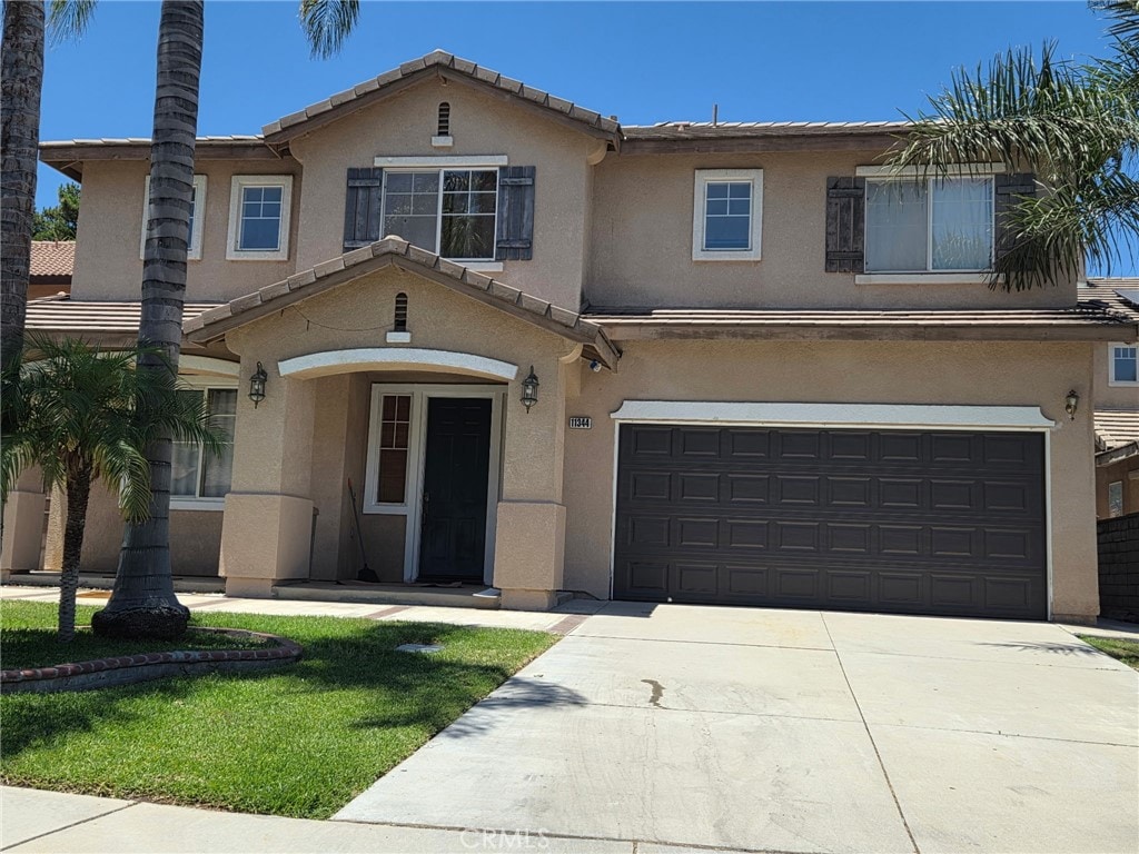 11344 Las Casas Ct, Fontana, CA 92337 - traditional-style home with stucco siding, a garage, driveway, and a tiled roof