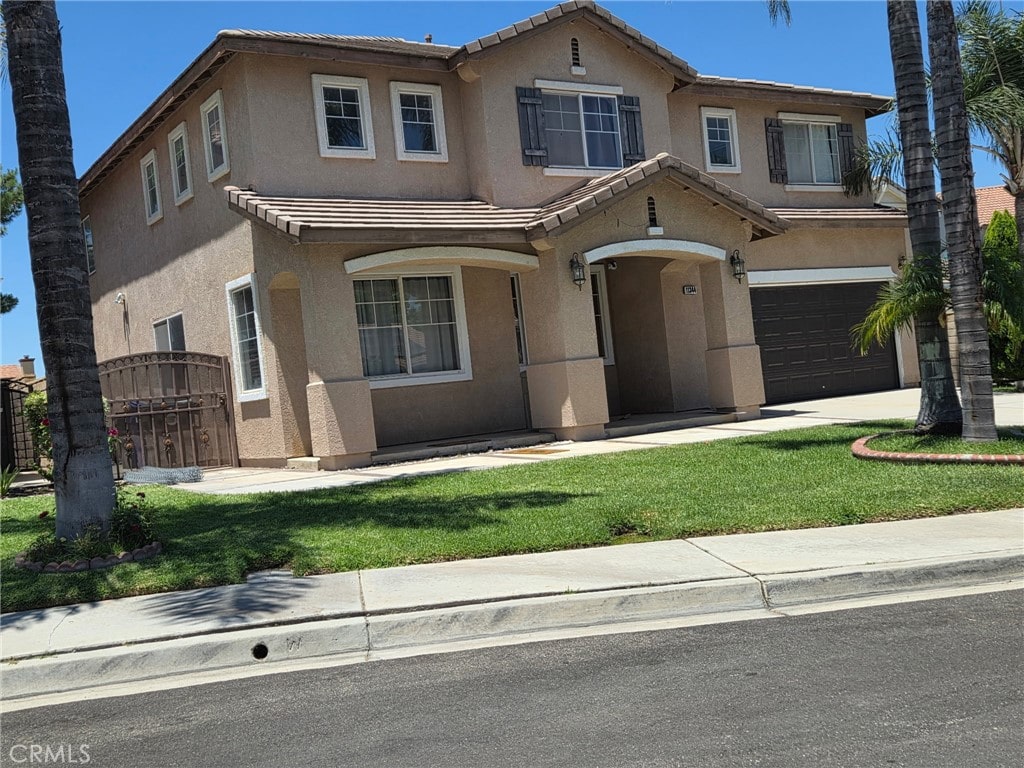 11344 Las Casas Ct, Fontana, CA 92337 - traditional-style house featuring stucco siding, a garage, a tile roof, and a front yard