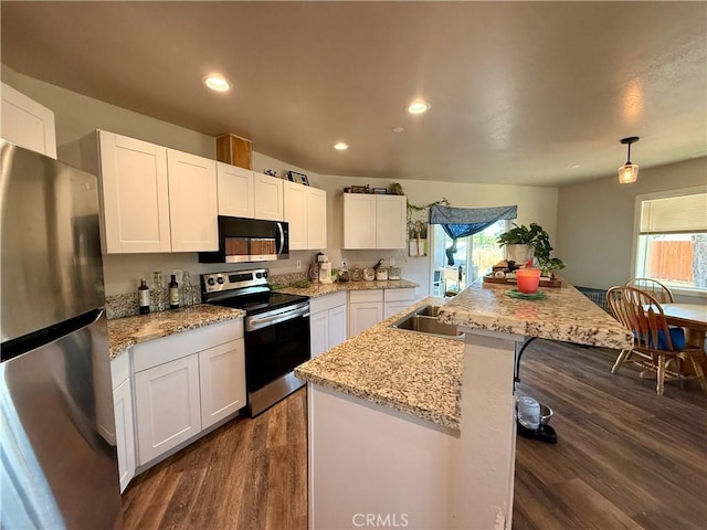 2048 10th St, Oroville, CA 95965 - kitchen with appliances with stainless steel finishes, dark wood finished floors, healthy amount of natural light, white cabinets, and recessed lighting