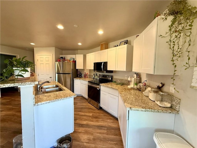 2048 10th St, Oroville, CA 95965 - kitchen with appliances with stainless steel finishes, an island with sink, white cabinets, recessed lighting, and dark wood-style floors