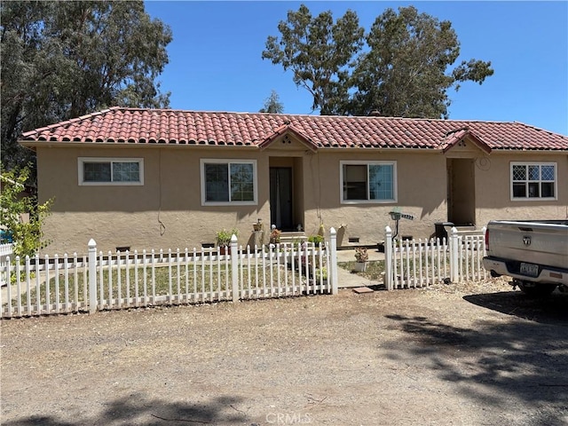 2048 10th St, Oroville, CA 95965 - mediterranean / spanish-style house with stucco siding, a fenced front yard, and a tile roof