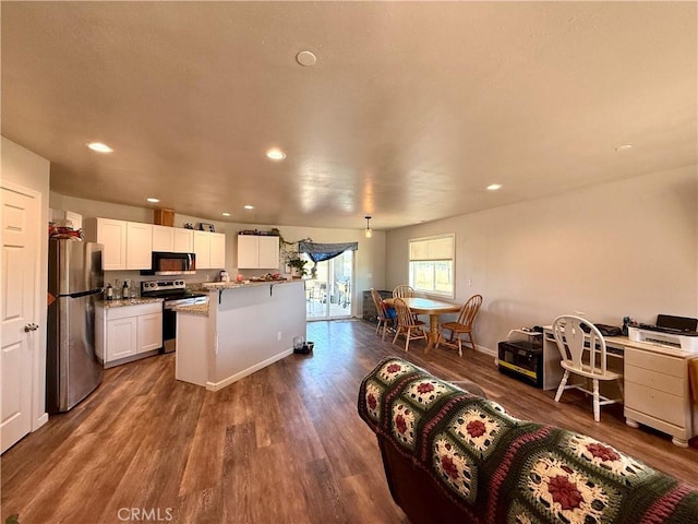 2048 10th St, Oroville, CA 95965 - kitchen with stainless steel appliances, dark wood-type flooring, white cabinetry, recessed lighting, and light stone countertops