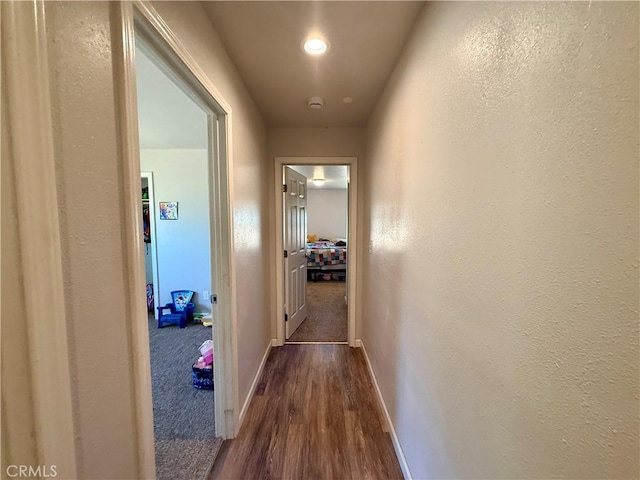 2048 10th St, Oroville, CA 95965 - corridor with dark wood-style flooring, a textured wall, and recessed lighting