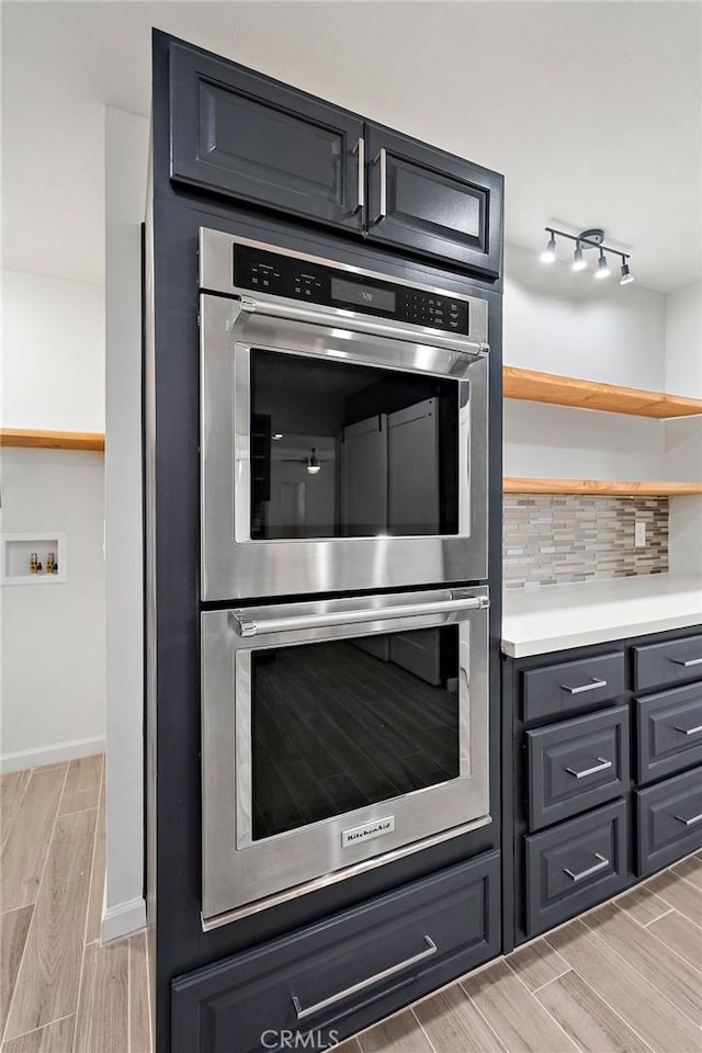 7573 Cibola Trl, Yucca Valley, CA 92284 - kitchen featuring double oven, wood finish floors, backsplash, open shelves, and light countertops