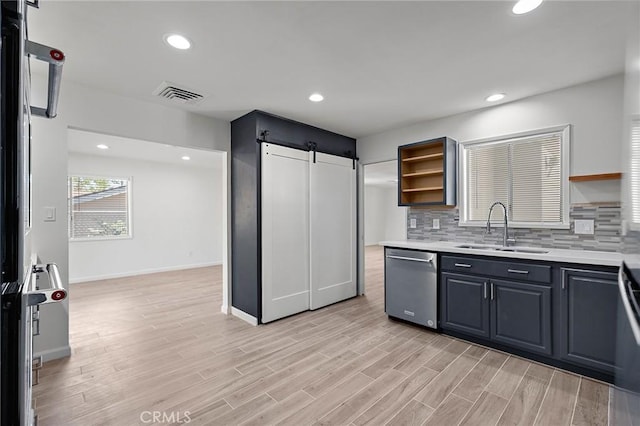 7573 Cibola Trl, Yucca Valley, CA 92284 - kitchen featuring dishwasher, open shelves, a barn door, light countertops, and tasteful backsplash