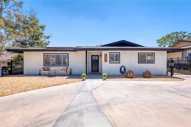 7573 Cibola Trl, Yucca Valley, CA 92284 - ranch-style home with stucco siding, roof mounted solar panels, and a gate