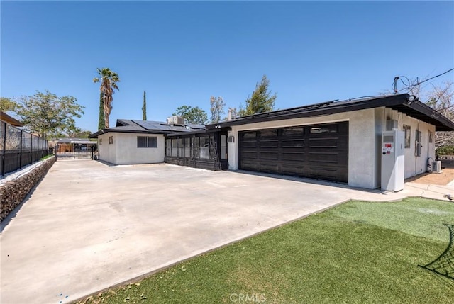 7573 Cibola Trl, Yucca Valley, CA 92284 - view of front of house with driveway, stucco siding, roof mounted solar panels, and a garage