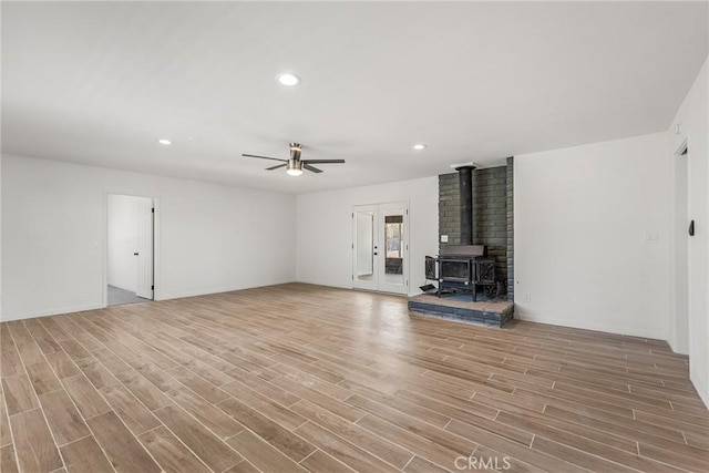 7573 Cibola Trl, Yucca Valley, CA 92284 - unfurnished living room featuring a wood stove, ceiling fan, light wood-style floors, and recessed lighting