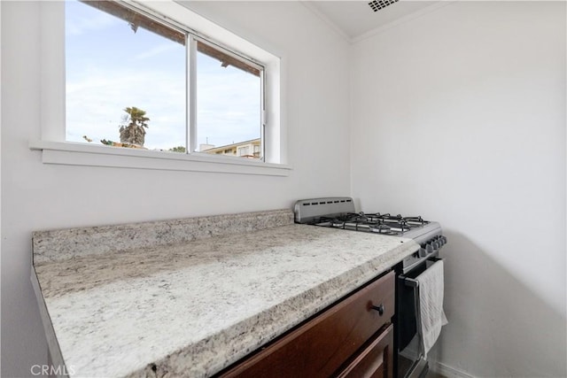 971 Ramona Ave, Los Osos, CA 93402 - kitchen featuring stainless steel range with gas cooktop, light countertops, ornamental molding, and dark brown cabinets