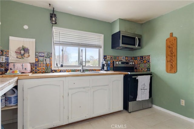 971 Ramona Ave, Los Osos, CA 93402 - kitchen with appliances with stainless steel finishes, white cabinets, tasteful backsplash, light tile patterned flooring, and light countertops