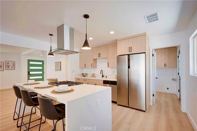 1810 N 2nd Ave, Upland, CA 91784 - kitchen featuring stainless steel appliances, island exhaust hood, light brown cabinetry, a breakfast bar, and a kitchen island