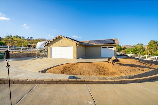 2575 Palomino Dr, Acton, CA 93510 - view of front of house featuring concrete driveway, roof mounted solar panels, an attached garage, and stucco siding