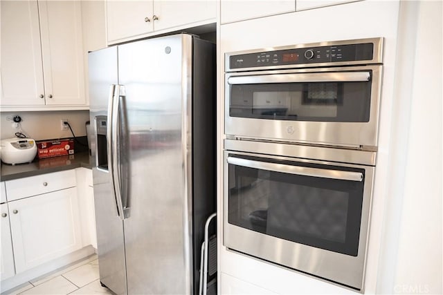21125 Normandie Ave, Torrance, CA 90501 - kitchen featuring appliances with stainless steel finishes, white cabinets, dark countertops, and light tile patterned flooring