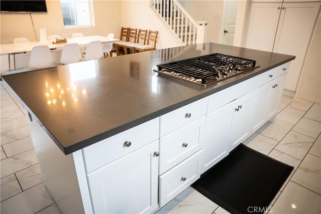 21125 Normandie Ave, Torrance, CA 90501 - kitchen featuring light marble finish floors, stainless steel gas cooktop, dark countertops, and white cabinetry