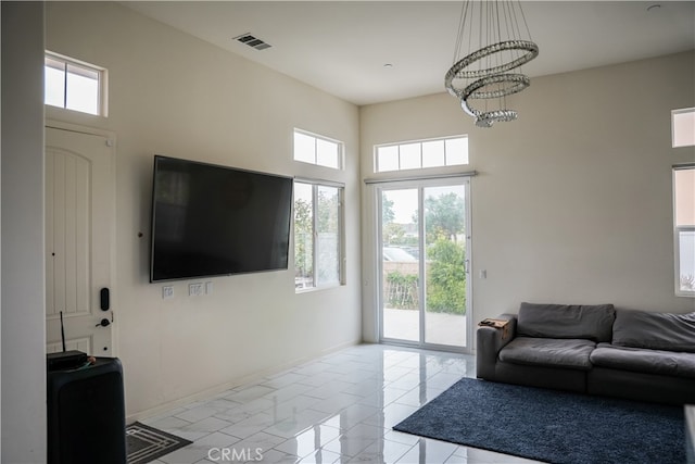 21125 Normandie Ave, Torrance, CA 90501 - living area featuring healthy amount of natural light, a high ceiling, a chandelier, and light marble finish flooring