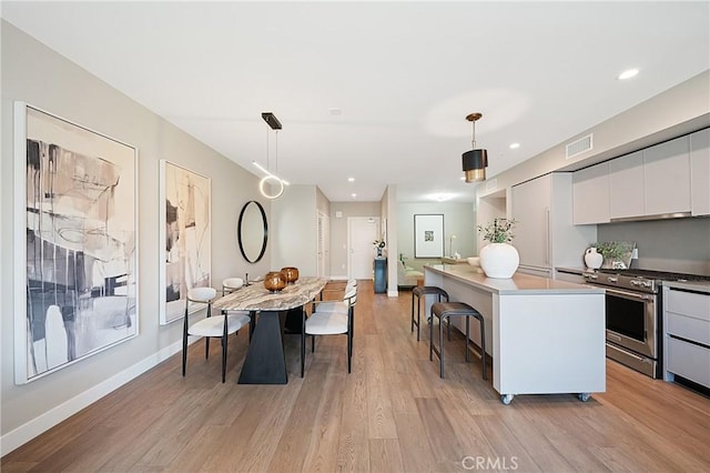 39 S Los Robles Ave Unit 6010, Pasadena, CA 91101 - kitchen featuring gas stove, modern cabinets, white cabinets, light wood finished floors, and a breakfast bar area
