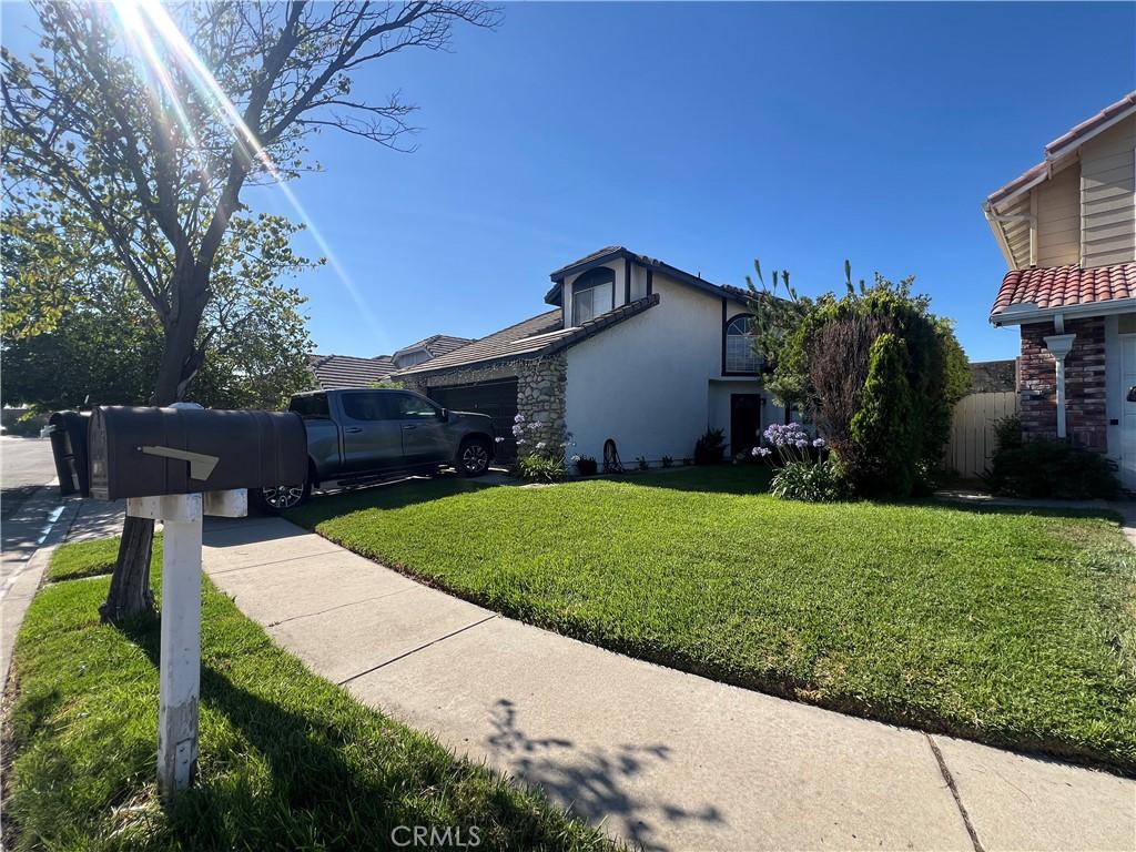 11839 Antler Peak Ct, Rancho Cucamonga, CA 91737 - view of side of home featuring a yard, stucco siding, an attached garage, and stone siding