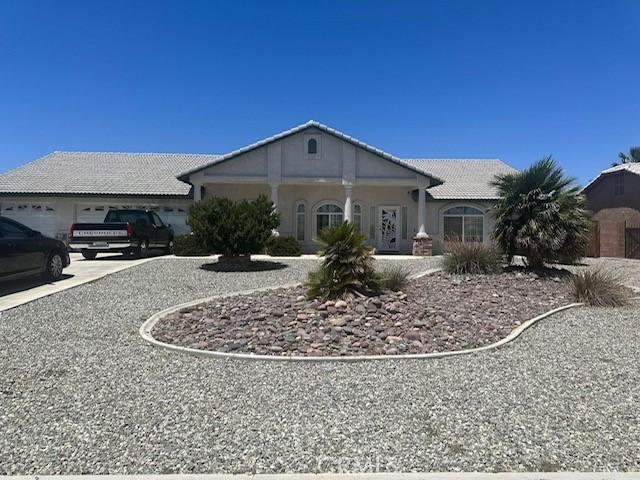 12710 Yorkshire Dr, Apple Valley, CA 92308 - view of front of home with driveway, a tile roof, stucco siding, and an attached garage