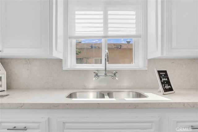 3341 Wisconsin Ave, South Gate, CA 90280 - kitchen featuring backsplash, white cabinetry, and light stone countertops