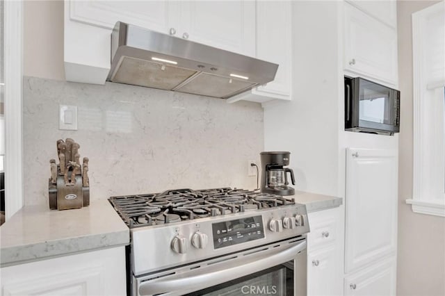 3341 Wisconsin Ave, South Gate, CA 90280 - kitchen featuring stainless steel gas range oven, under cabinet range hood, black microwave, decorative backsplash, and white cabinetry