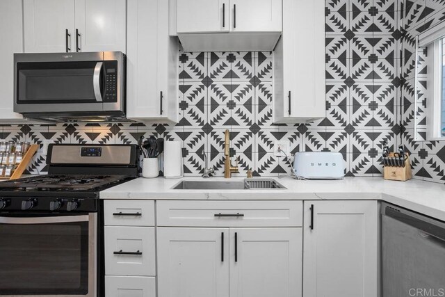 803 S Pacific St Unit 1, Oceanside, CA 92054 - kitchen featuring appliances with stainless steel finishes, tasteful backsplash, light countertops, and white cabinetry