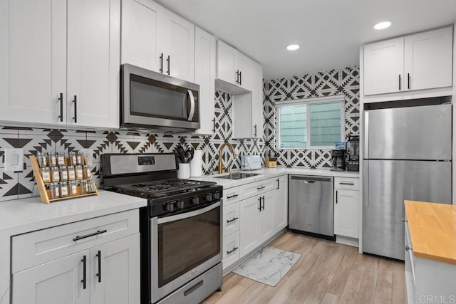 803 S Pacific St Unit 1, Oceanside, CA 92054 - kitchen with stainless steel appliances, white cabinetry, light wood finished floors, tasteful backsplash, and recessed lighting