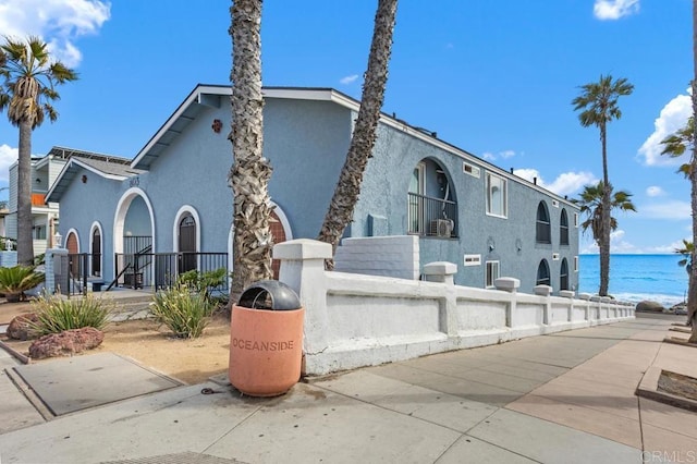 803 S Pacific St Unit 1, Oceanside, CA 92054 - view of front of property featuring a fenced front yard, stucco siding, and a water view