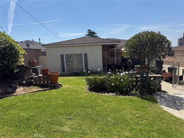1617 W 125th St, Los Angeles, CA 90047 - rear view of house with stucco siding, a patio, and roof with shingles