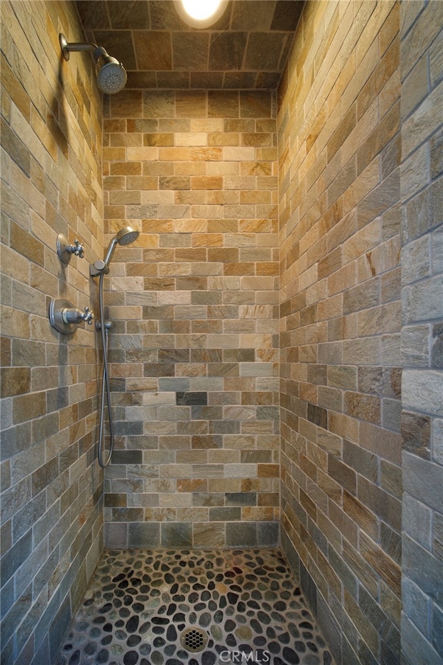3908 Channel Pl, Newport Beach, CA 92663 - bathroom with a tile shower, stone finish floors, and brick wall