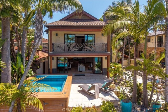 3908 Channel Pl, Newport Beach, CA 92663 - back of property with a balcony, a patio, stucco siding, roof with shingles, and an outdoor pool