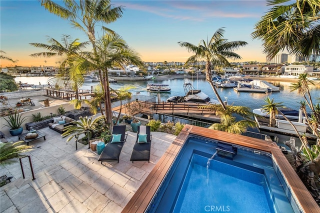 3908 Channel Pl, Newport Beach, CA 92663 - pool at dusk featuring a water view, a patio, a boat dock, and an outdoor pool